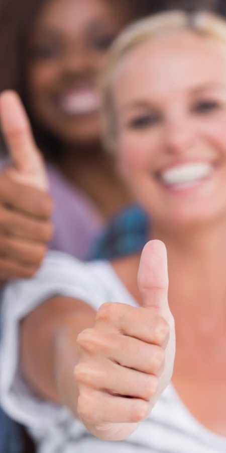 Happy fashionable group giving thumbs up on white background